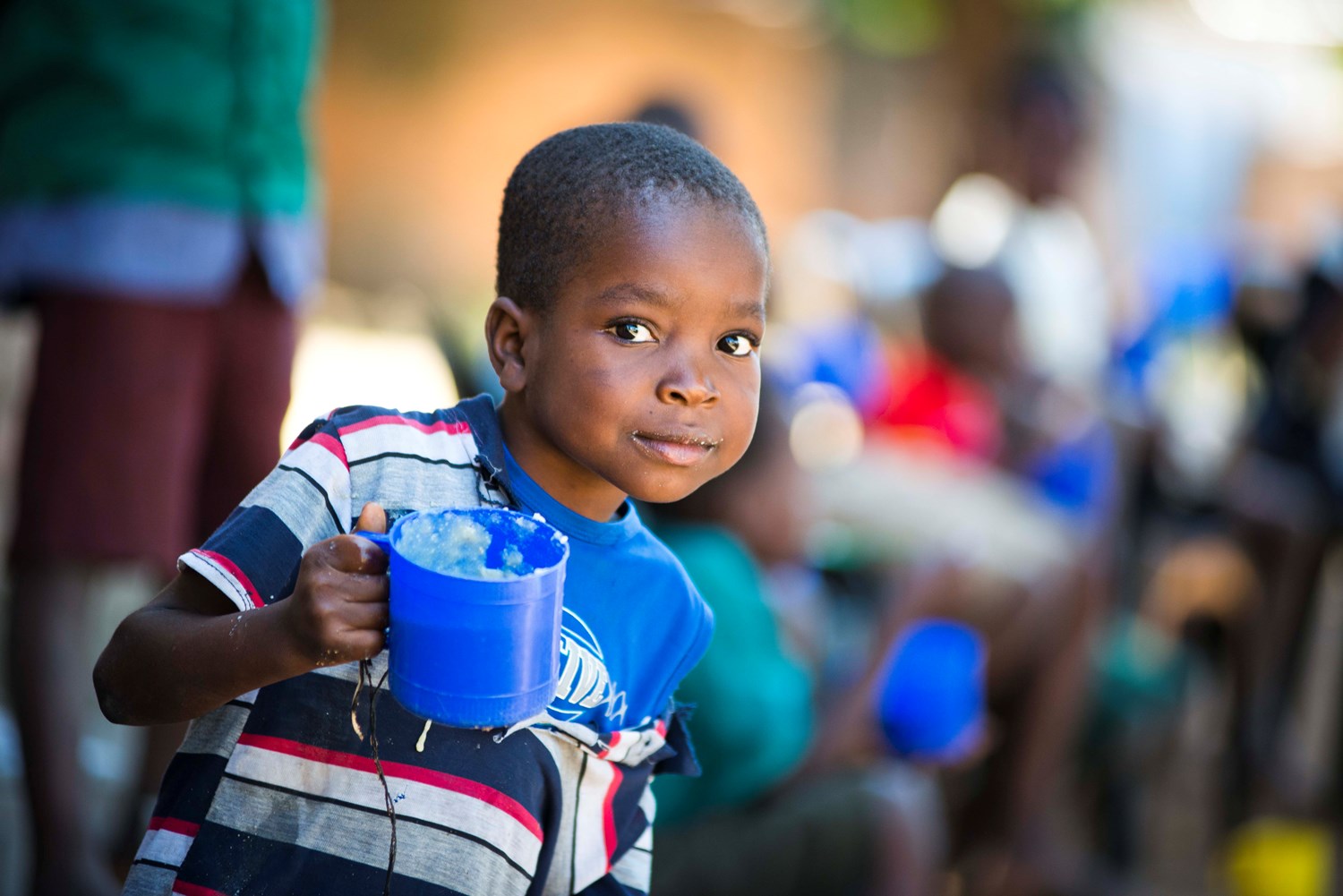 Boy holding a blue cup